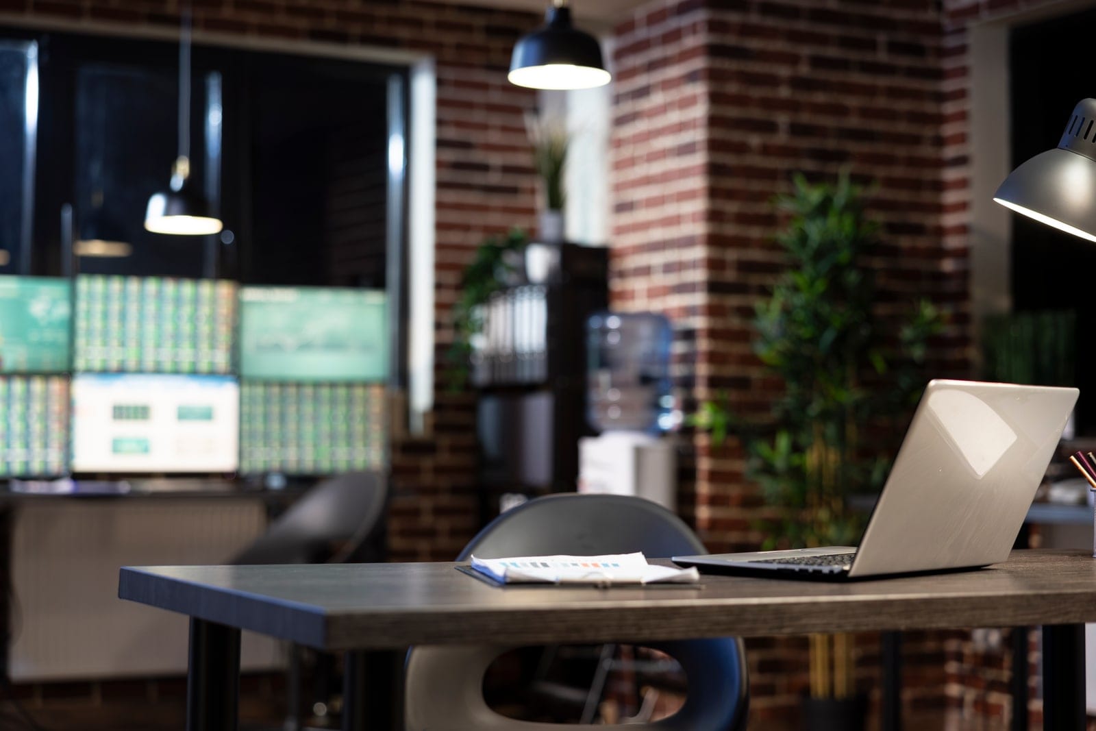 Unoccupied desk and laptop in a small office after hours